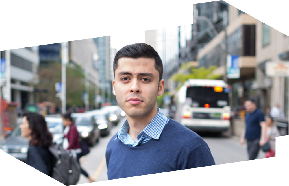 Recent Mechanical and Industrial Engineering graduate, Farbod Mansorian, stands in a major downtown intersection.