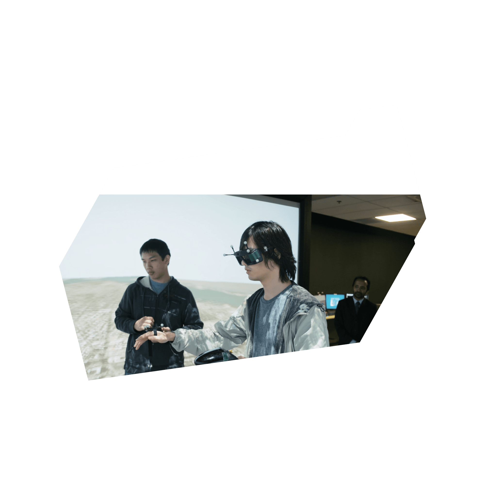 Masters student Randy Tan and PhD Candidate Zheng Wu stand inside an open cube structure with visualizations projected on the sides. Zheng Wu wears virtual reality glasses and holds controls for manipulating the visualizations. Naimul Khan, a professor in Electrical and Computer Engineering in the Faculty of Engineering and Architectural Science, watches from behind.