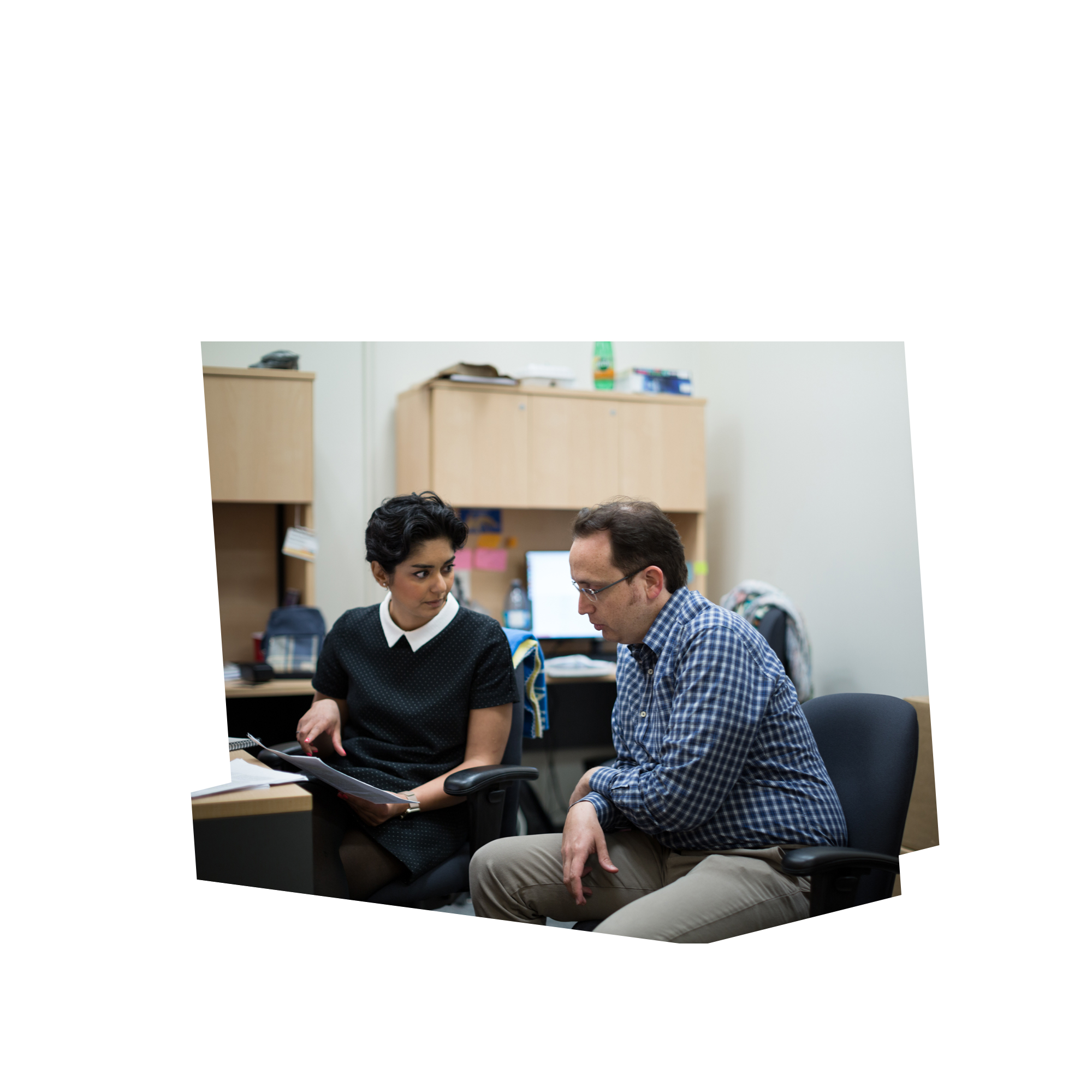 Mechanical and Industrial Engineering Phd students Parisa Lak and Cas Kavaklioglu discuss details in reference to a printed document while seated in a Ryerson office.